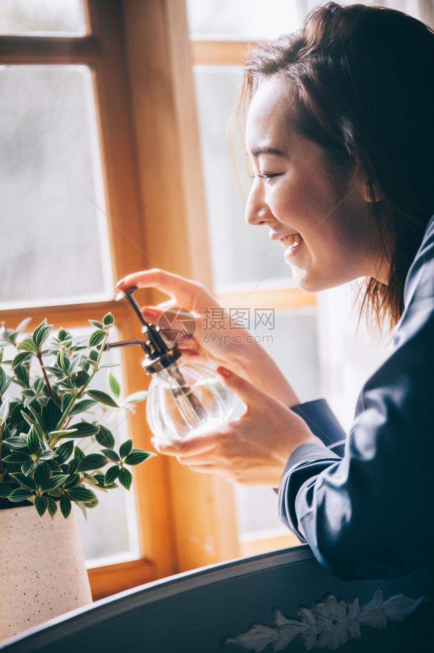 给植物浇水的居家女性图片