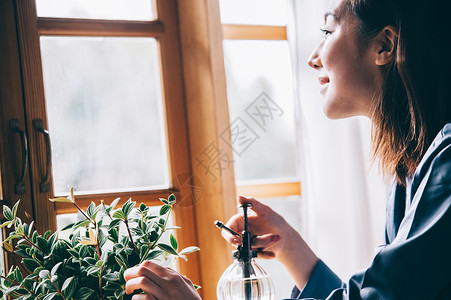 给植物浇水的居家女性图片