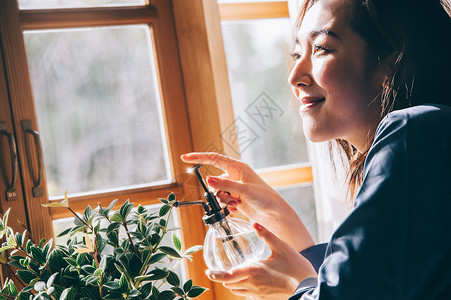 给植物浇水的居家女性图片