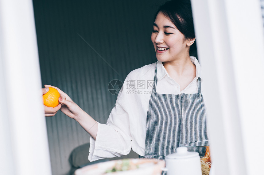 愉快的女人拿着橙子图片