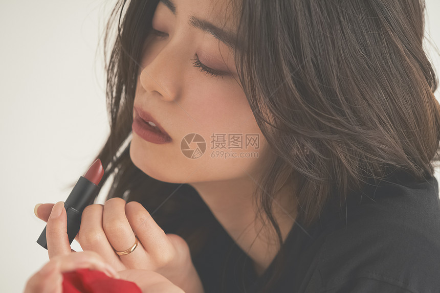 手拿口红的女青年图片