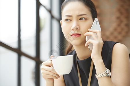 坐在窗台边上接打电话的女性图片