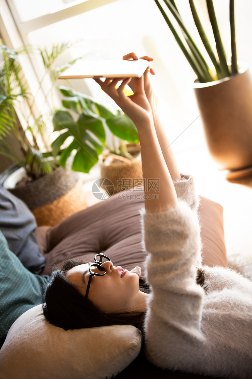 举起平板电脑的女青年图片