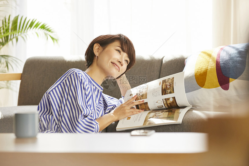 居家看杂志放松的成年女子图片