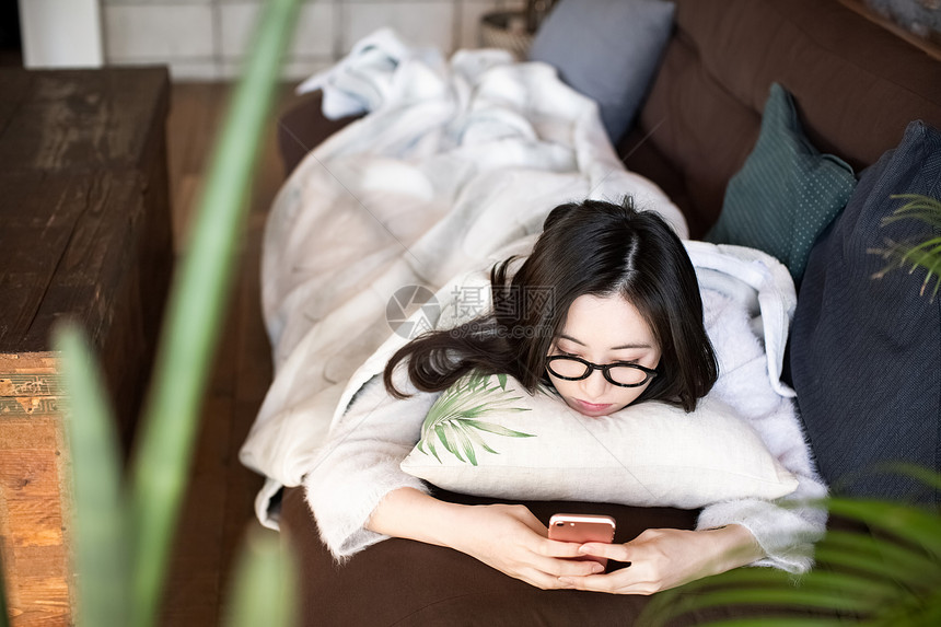 趴在沙发上看手机的女人图片