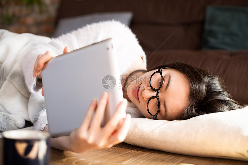 躺着看平板电脑的女青年图片