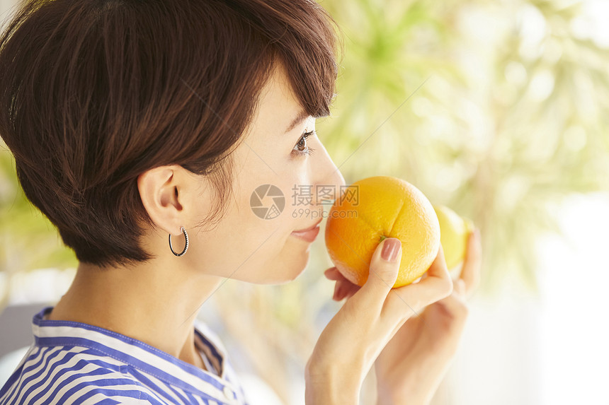 愉悦着闻橘子香甜的女人图片