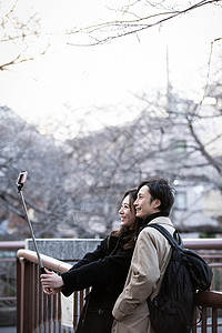 冬天旅游轻松一对夫妇与智能手机拍照图片