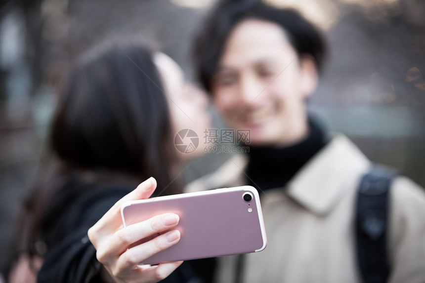 假期一对夫妇亲吻用智能手机拍照图片