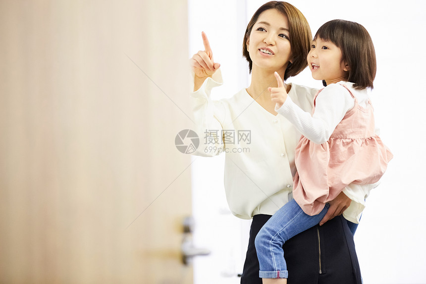 母亲抱着女儿指着说话图片