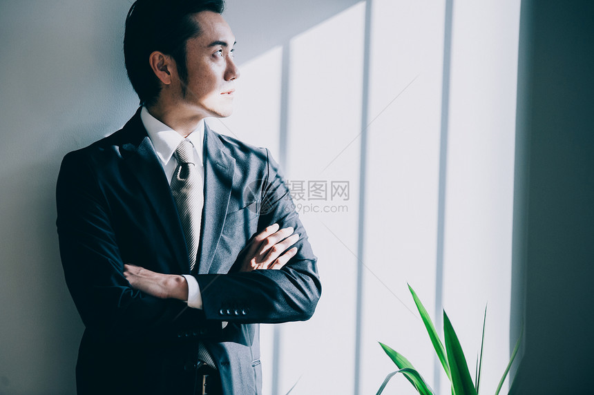 男人黑发卓越站立对白色墙壁的上司男图片