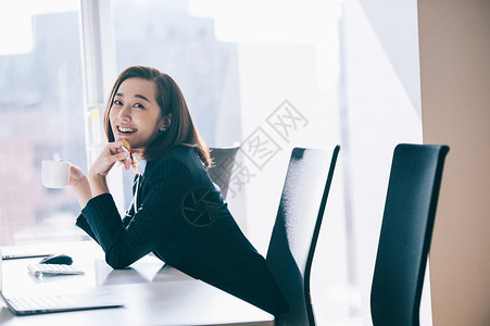 有能力的公司职员行销一个女人在前往电脑时拿起糖果图片