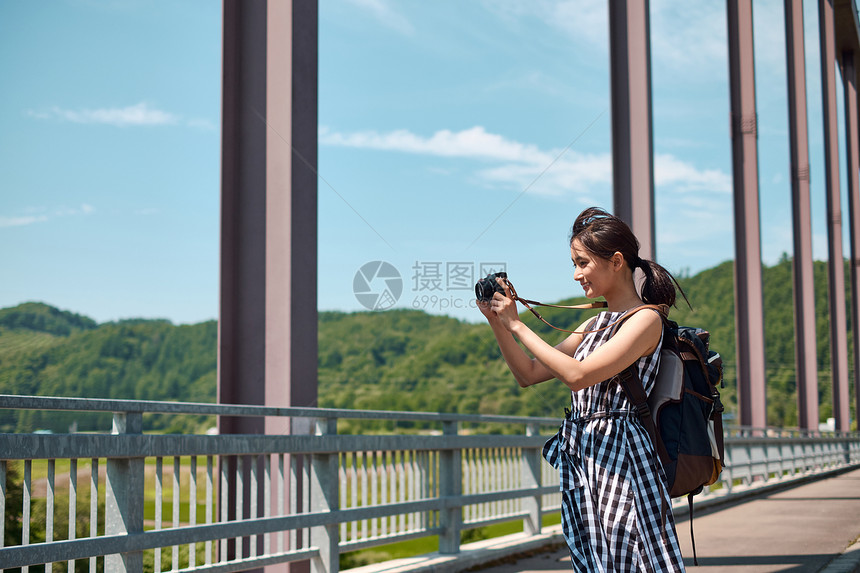 户外旅游拍照记录的年轻女子图片