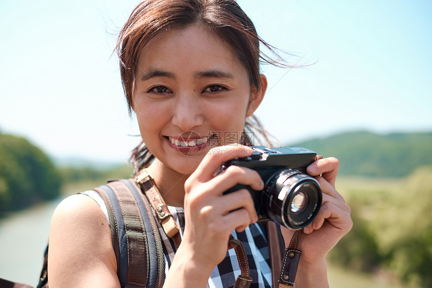 观光旅游拿着相机的女青年图片