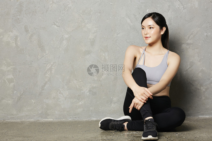 坐在地上休息的健身女性图片