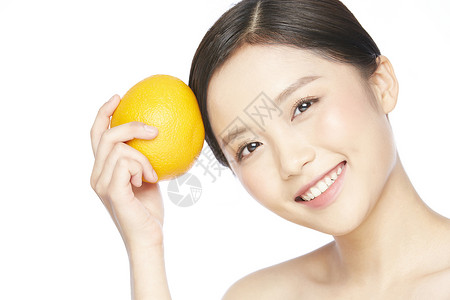 橘子女孩拿着橙子微笑的护肤美女背景