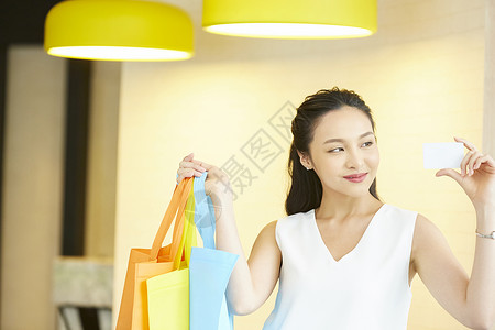 购物中心积分卡手拿购物袋的女子背景