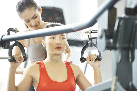 健身房教练指导女学员使用器械图片