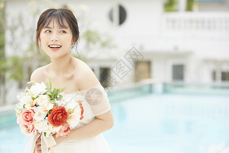 泳池边拿着手捧花的新娘图片