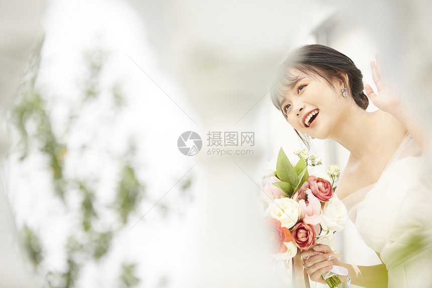 手拿鲜花的穿婚纱的新娘图片
