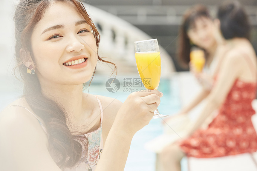 度假酒店泳池的女人喝果汁图片