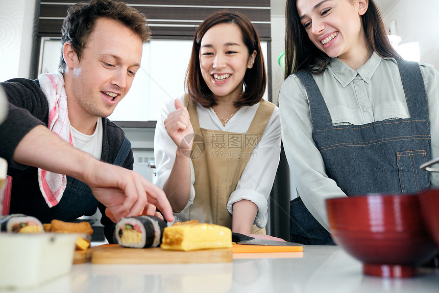 青年男女学习日本寿司制作图片