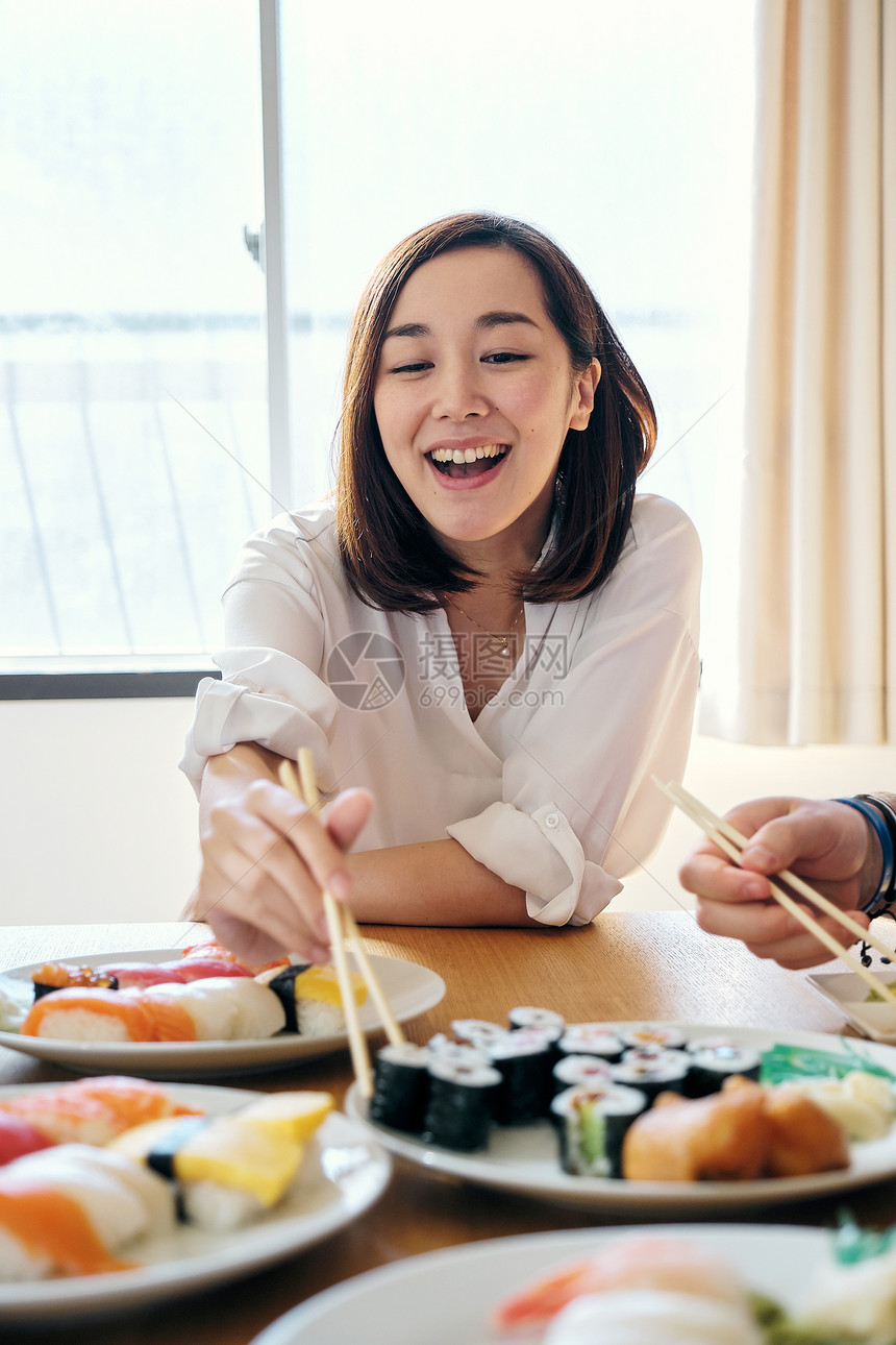 快乐孤独的家居派对吃寿司的妇女图片