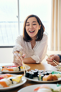 快乐孤独的家居派对吃寿司的妇女图片
