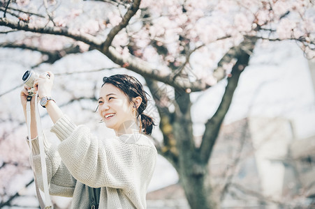 30多岁享受单人樱花拍照片的春天妇女高清图片