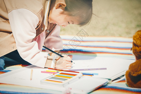 户外野餐画画的小女孩图片