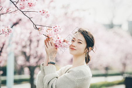 美丽的樱桃树户外享受樱花的女子背景