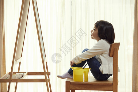 坐在桶上桶青春室内坐在画架前面的女孩在客厅背景