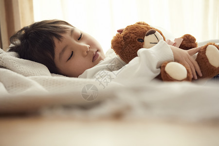 小孩孩子3岁睡觉与小熊的女孩在床上背景图片