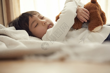 晚安小女孩打盹睡觉与小熊的女孩在床上背景图片