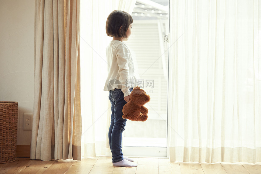 较年轻儿童看见支持一只小熊的女孩窗口图片