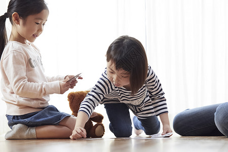 小朋友和幼教一起玩纸牌图片