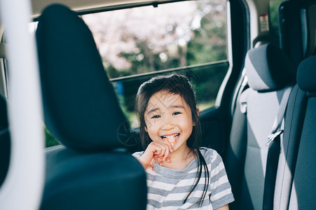 坐在汽车上吃东西的女孩图片