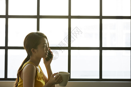 拿着咖啡打电话的商务女性图片