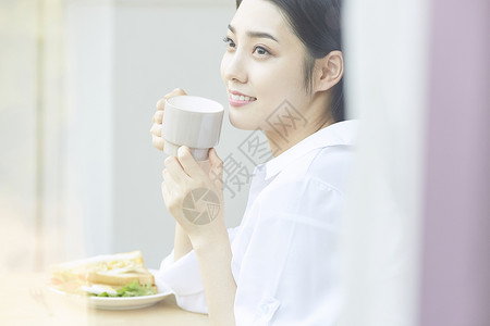 吃面包喝茶的年轻女孩图片