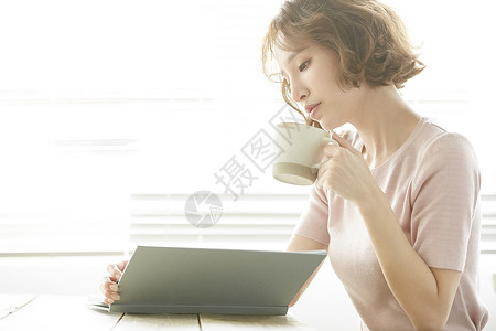 室内阅读喝茶的美丽少女图片