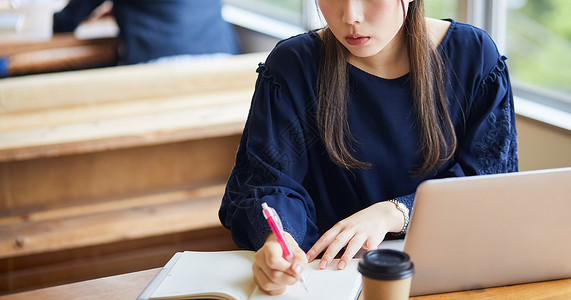 室内正在记笔记的年轻女人图片