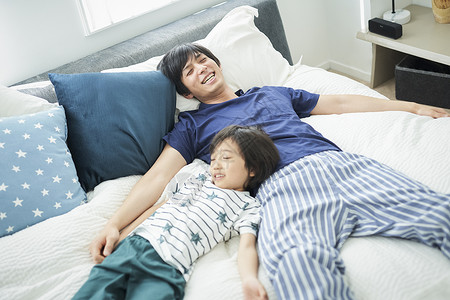 男人们人类户内父母和孩子的生活方式床图片