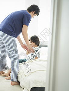 夏亚洲人男父母和孩子的生活方式床图片