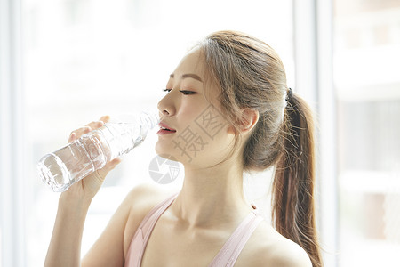 做伸展运动的女人喝水图片
