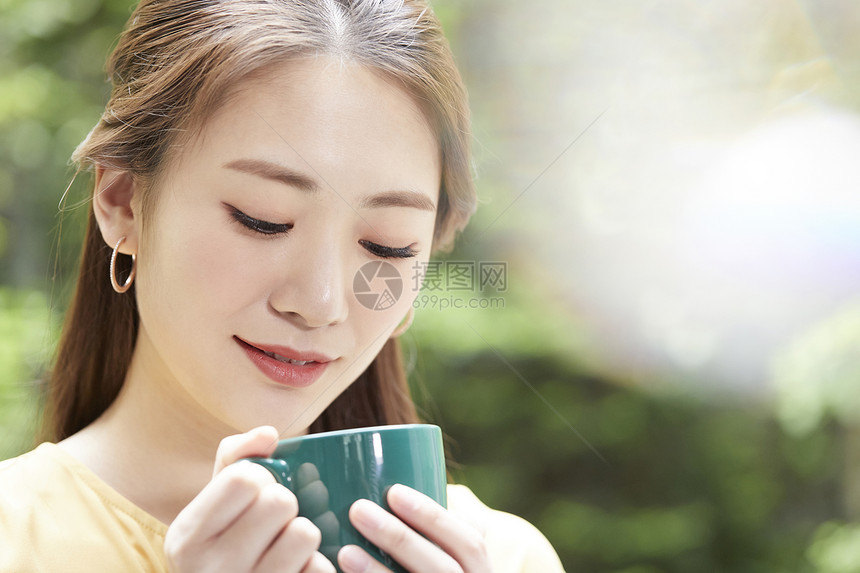手拿咖啡喝下午茶的青年女子图片