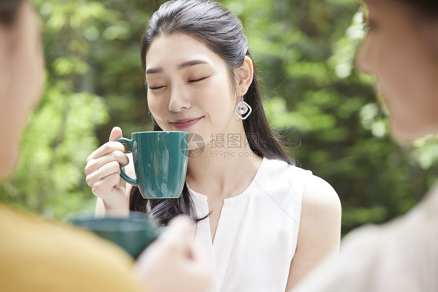 手拿咖啡喝下午茶的青年女子图片