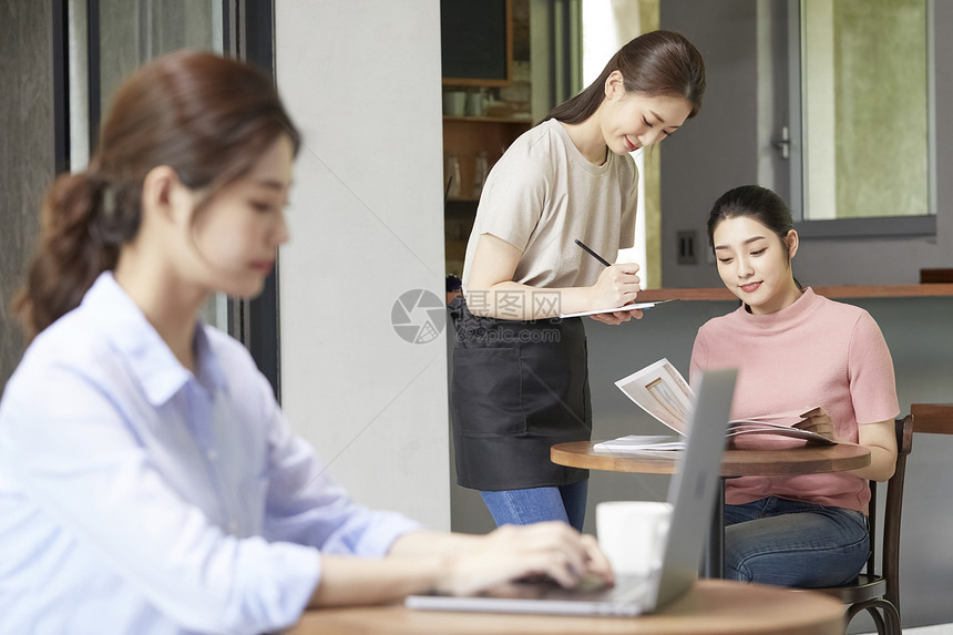 青年女子拿着菜单点单图片