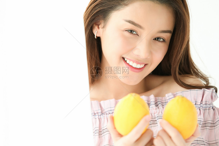 拿着柠檬的年轻女子图片