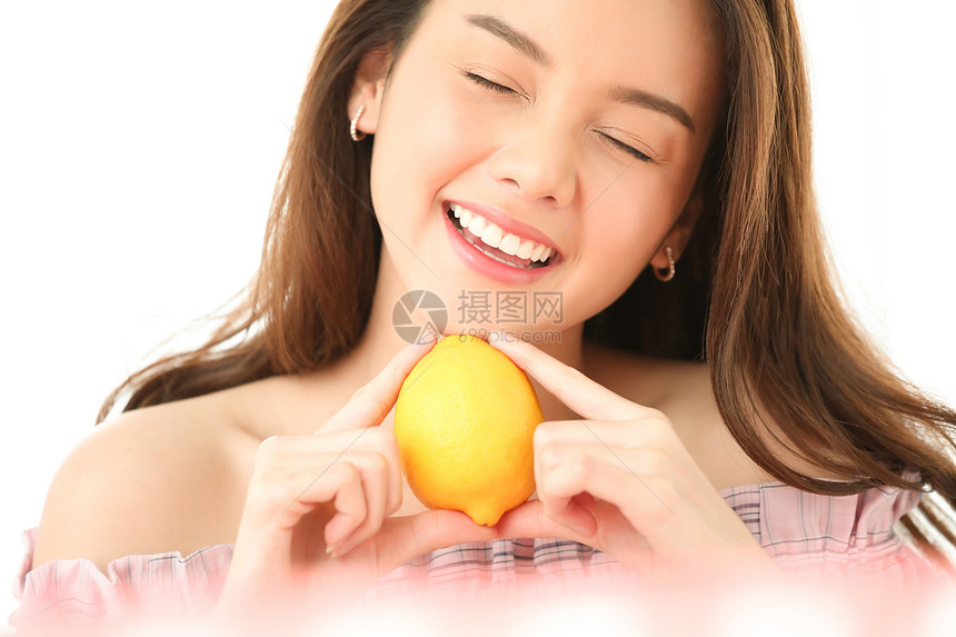 拿着柠檬微笑的年轻女子图片