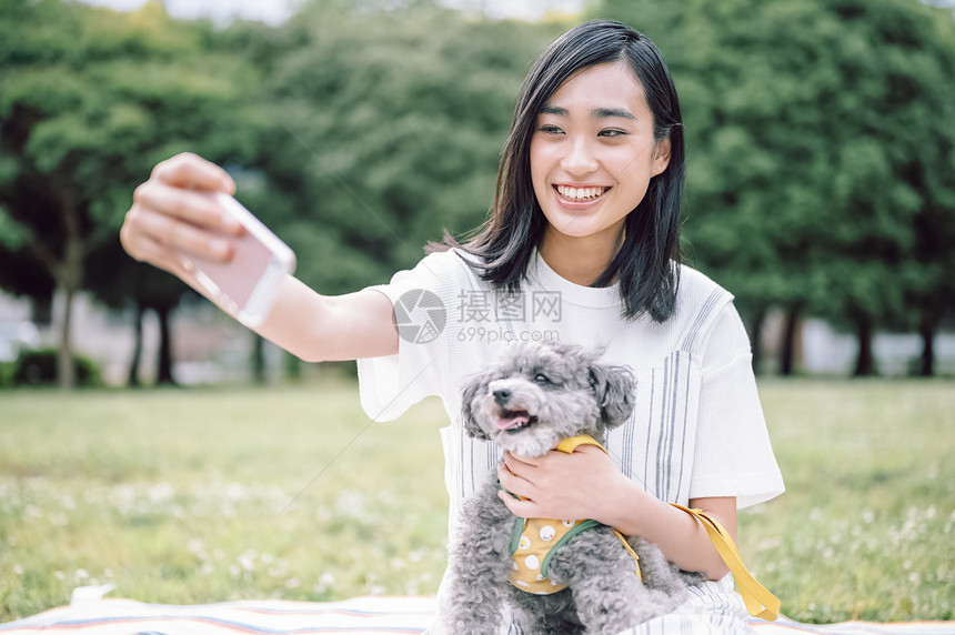 户外抱着宠物的女人自拍图片